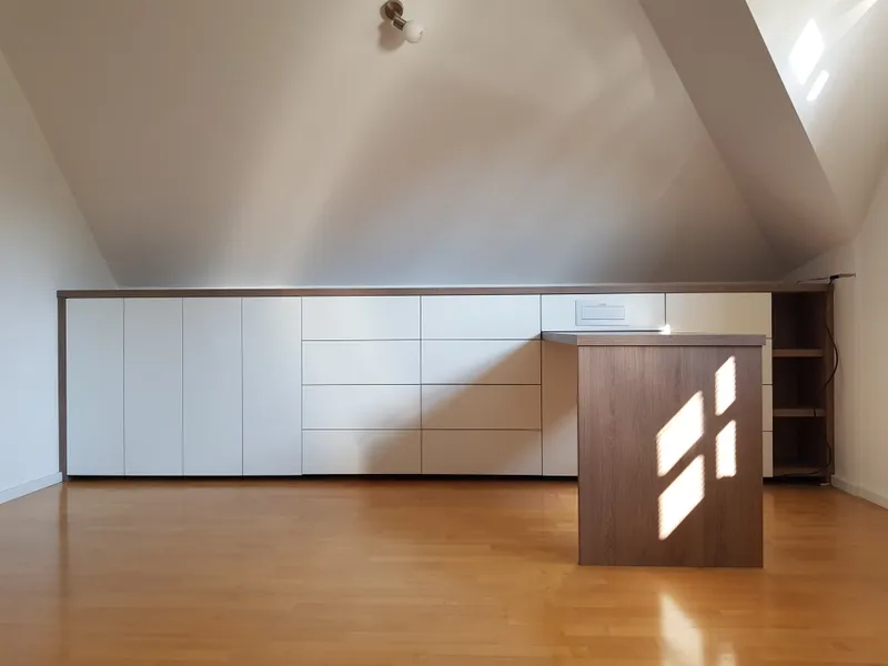 Delovna miza pod mansardnim oknom z vgrajenimi policami